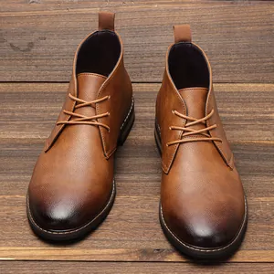 Vue de dessus détaillée de bottines desert classiques en cuir marron sur un fond bois