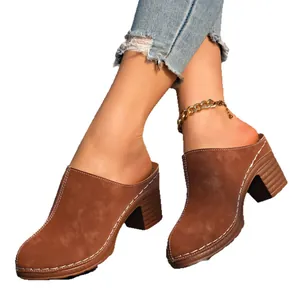 Mules élégantes en daim marron à talons épais avec des coutures blanches décoratives.