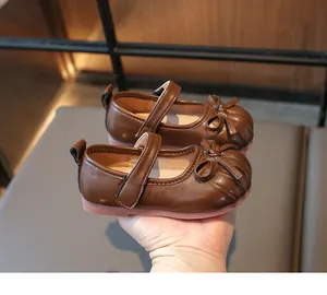 Detailed view of brown toddler princess shoes featuring a classic bow and soft sole