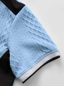 Gros plan sur le tissu en tricot jacquard bleu et le poignet contrasté d'un t-shirt homme