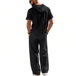 Back view of men's black linen short-sleeved hooded shirt and wide-leg trousers set.