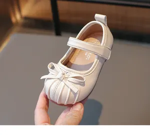 Elegant beige girls Mary Jane shoes featuring a pleated toe and a cute bow detail.