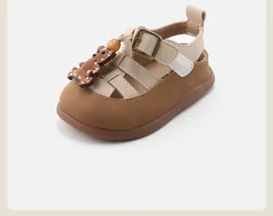 Close-up detail of toddler soft sole sandal with a cute cartoon bear decoration.