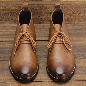 Vue de dessus de bottines désert marron pour hommes avec bout poli sur fond bois.