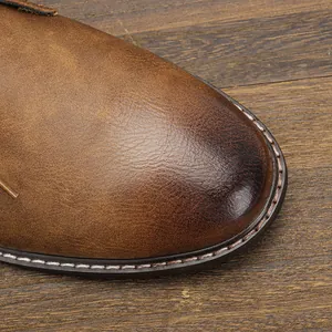 Gros plan sur la texture du cuir marron poli des bottes de désert pour hommes