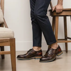 Vista dettagliata di scarpe Derby da uomo in pelle marrone vintage con pantaloni blu