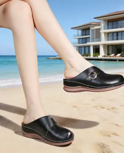 Detailed view of women's black platform clogs with stylish buckle and contrast stitching.