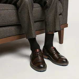 Dettaglio scarpe eleganti in pelle marrone vintage da uomo con design stringato e punta