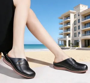 Detailed side view of black leather wedge sandals for women worn on a sunny beach background