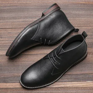 Vue de dessus montrant le cuir grainé des bottines desert noires sur bois sombre