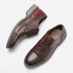 Dettaglio di scarpe casual da uomo in pelle marrone con tacco bordeaux e suola blu