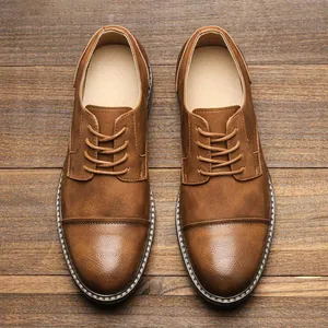 Vintage brown men's casual dress shoes with lace-up detail on wood background