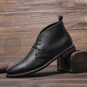 Détail latéral de bottines chukka noires pour hommes en cuir avec texture grainée.