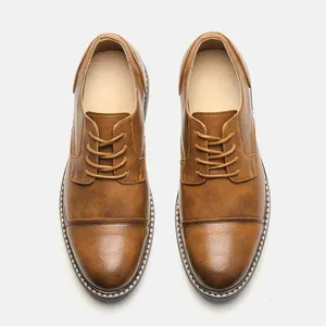 Detailed top view of classic tan leather Oxford dress shoes with cap-toe stitching