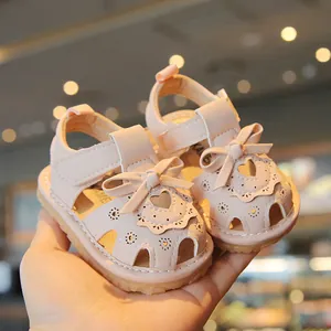Pink baby girl summer sandals with large bow and hollow heart design, soft sole.