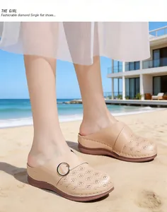Comfortable beige perforated wedge mules for women displayed in a sunny beach lifestyle setting.