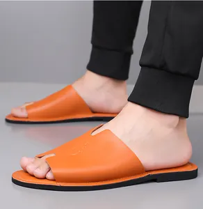 Detailopname van oranje herenleren slippers met een stijlvol uitgesneden bovenwerk
