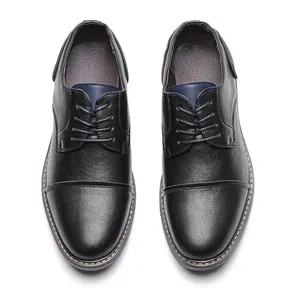 Vista macro dall'alto di scarpe eleganti da uomo in pelle nera con dettagli blu navy
