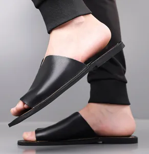 Close-up zijaanzicht van zwarte leren heren slippers aan de voet