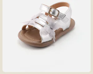 Close-up of silver toddler sandals featuring delicate lace butterfly decorations