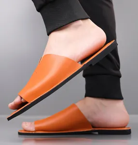 Gedetailleerd overzicht van stijlvolle feloranje heren slippers met een platte zwarte zool