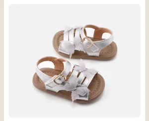 Detailed view of silver girl's sandals with lace butterfly appliques and buckle.