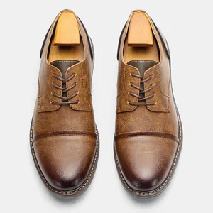 Top-down macro view of brown vintage leather dress shoes with wooden shoe trees.