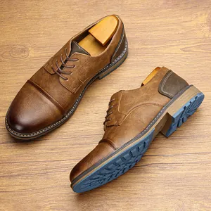 Vintage brown men's oxford leather shoes featuring textured blue soles on wood grain surface