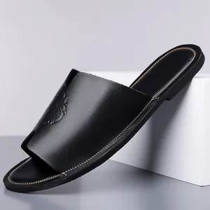 Klassieke zwarte leren herenslippers met reliëf leeuwenkop en contrasterende stiksels