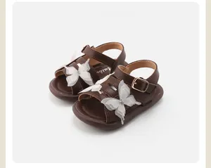 Close-up of brown toddler girls sandals featuring delicate white lace butterfly accents