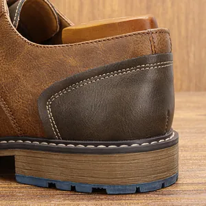 Macro view of vintage brown leather men's shoe heel showing fine stitching detail.