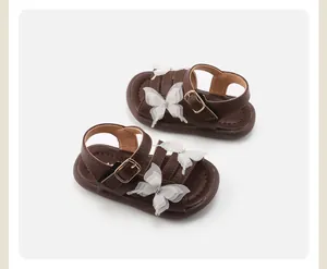 Detailed view of brown baby girl sandals featuring elegant white lace butterfly accents