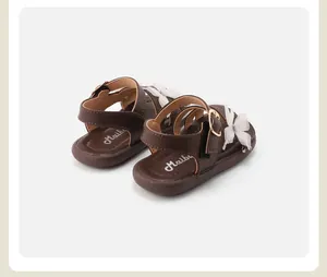 Detail shot of brown toddler girl sandals with elegant white lace butterfly accents