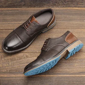 Vintage men's brown leather dress shoes with blue anti-slip sole on wood background