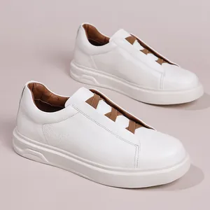 Stijlvolle witte herensneakers van rundleer met bruine elastische banden in slip-on stijl