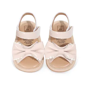 Vue détaillée de sandales roses pour bébé avec nœud festonné et velcro