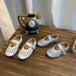 Detailweergave van wit en zilver opengewerkte Mary Jane schoenen voor meisjes