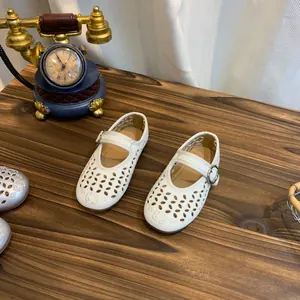 Bovenaanzicht van witte Franse opengewerkte Mary Jane schoenen op een houten tafel