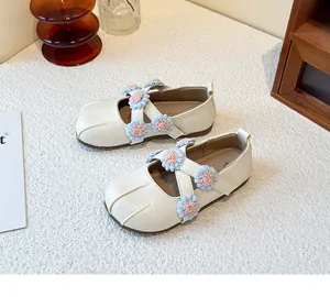 Close-up of cream girls Mary Jane shoes with pink and blue flower cross straps