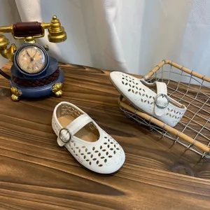 Detailopname van elegante witte Mary Jane schoenen met verfijnde opengewerkte patronen