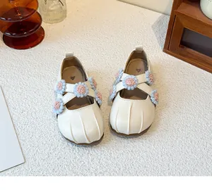 Detailed view of cream Mary Jane shoes with colorful flower decorations for girls