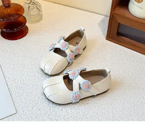 Detail view of girls cream Mary Jane flats with pink and blue floral cross straps