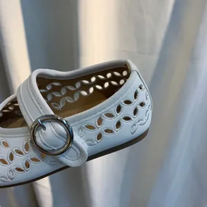 Detail van witte Mary Janes voor meisjes met verfijnde geborduurde bloemmotieven