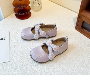 Detail view of girls' lavender Mary Jane shoes with cute floral cross-strap design.