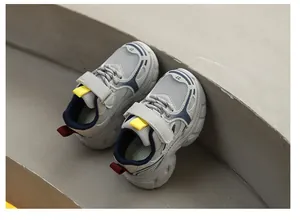 Dettaglio di sneaker per bambini in mesh grigio traspirante su gradini di pietra