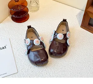 Detailed view of dark burgundy girl's Mary Jane shoes with delicate floral cross straps