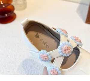 Close-up of girl's white Mary Jane shoes featuring delicate pastel flower decorations