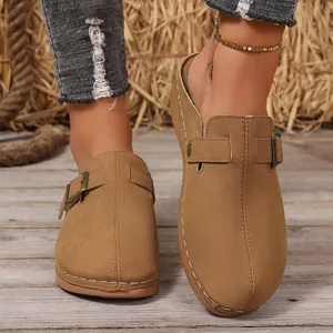 Casual women's tan closed-toe mules with buckle strap and white stitching details