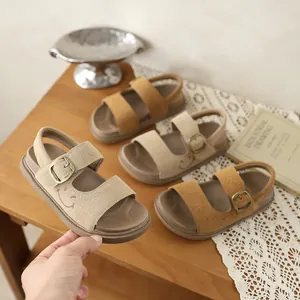 Tre paia di eleganti sandali in pelle scamosciata per bambini in tonalità terra.