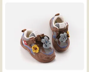 Detail view of brown toddler sneakers with cute knitted rabbit and flower decorations.